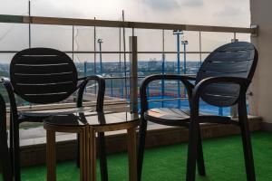 ラホールにあるGold Crest Luxury Hotel Apartments-City View DHA Lahoreの窓の前に椅子2脚とテーブル1台