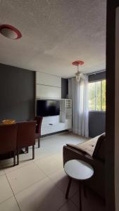 a living room with a couch and a dining room at Apartamento da Letícia in Camaçari
