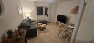 Una sala de estar con un sofá y un televisor. en Ferienwohnung Horsti, en Timmendorfer Strand