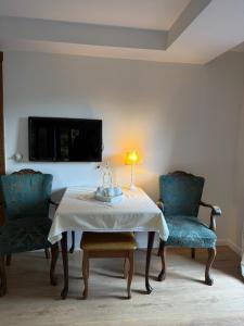 a room with a table and two chairs and a tv at Pensjonat Alpejski Dwór in Miedzygorze