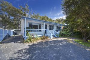 a blue and white house with a fence at Happy House - Pet Friendly - 5 Min Walk to Beach in Callala Beach
