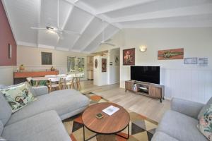 a living room with a couch and a table at Happy House - Pet Friendly - 5 Min Walk to Beach in Callala Beach