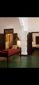 a bedroom with a bed with a red bedspread at Elephant Heritage Pinnawala by Moon Isle in Rambukkana