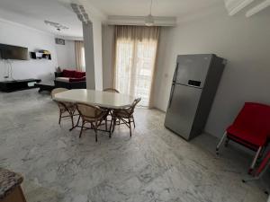 a living room with a table and a refrigerator at chott meriem cozy apartment in Akouda