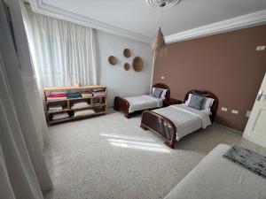 a living room with two beds and a window at chott meriem cozy apartment in Akouda
