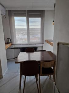 a table and chairs in a room with a window at Blue New Yorker in Niš