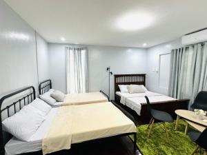 a room with two beds and a table and chairs at Matthews Home Cebu-Casa Uno in Cebu City