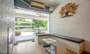a living room with a bench and a large window at Hotel SouthEnd in Chandīgarh +8 photos
