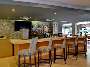 a bar in a restaurant with four stools at ANEW Hotel Roodepoort Johannesburg in Roodepoort +107 photos