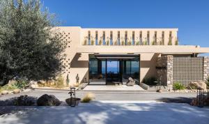 a large building with glass doors in a yard at ​Le Grand Bleu Resort in Derveni