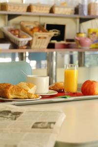 a tray with a plate of food and a glass of orange juice at LIBERTY Hôtel Rennes Ouest in Vezin-le-Coquet