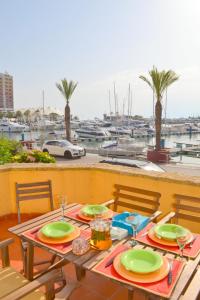 a table with green plates on a balcony with a marina at TP Coral 1 - Marina Vilamoura Apartment in Vilamoura