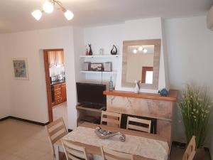 a living room with a table and a television at Villa Samba, luminosa y céntrica con piscina in Cala en Blanes