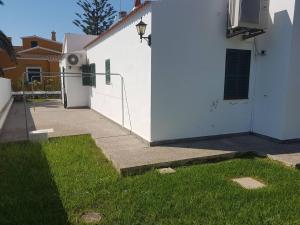 a white house with a refrigerator next to a sidewalk at Villa familiar con piscina privada en Calan Blanes in Cala en Blanes
