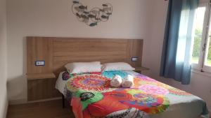 a bed with two stuffed animals sitting on top of it at Casa Palmeres in Torroella de Montgrí