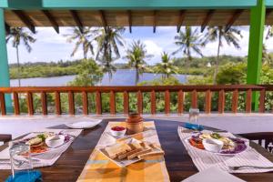 a table with food on it with a view of the water at Atulya Lake View Mirissa - Resort and Spa in Mirissa