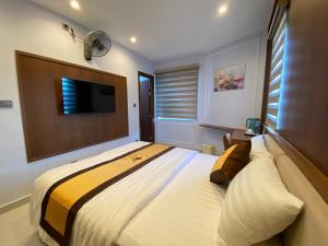 a bedroom with a large bed and a flat screen tv at Hoàng Long Hotel in Chợ Phước Hải