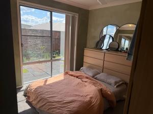 een slaapkamer met een bed en een groot raam bij The Atelier Artful Home Stay at Mangohill in North Lakes