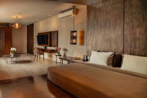 a bedroom with a large bed and a living room at INSPIRA Seminyak in Seminyak