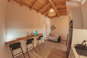 サンミゲル・デ・アボナにあるLuxurious apartment in southern Tenerifeのキッチン、リビングルーム(カウンター、スツール付)