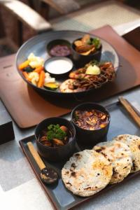 a tray of food with bowls of food on a table at Beldon Boutique Hotel in Hiriketiya