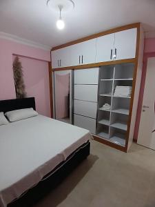 a bedroom with a large white bed and a closet at Sin House in Pamukkale