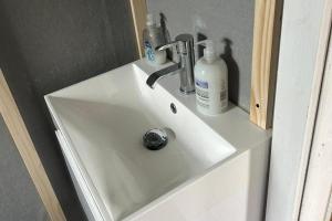 a sink with a faucet and bottles on it at Glamping Hut - Sleeps up to 4 Hot Tub & Parking in Welshpool +16 photos