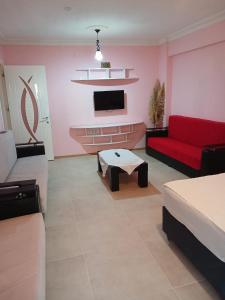 a living room with a red couch and a tv at Sin House in Pamukkale