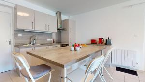 een keuken met een grote houten tafel en stoelen bij Parenthèse à Eguisheim in Eguisheim +18 foto's