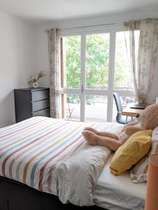 a bedroom with a bed with a large window at Évasion La Défense - Balcon & Wi-Fi, à 10 min de Paris in Courbevoie +17 photos