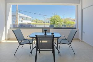 a table and chairs on a balcony with a window at Isol Rooms Β1 in Katerini
