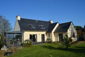 a white house with a black roof at Magnifique villa vue mer ploumanac'h in Perros-Guirec