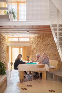 een groep mensen die aan een tafel in een kamer zitten bij Casa rural Felipa in Casas de Pradas