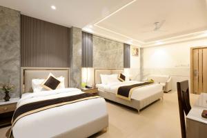 新德里Dahabi Era Delhi Airport - 9 min fr Airport的一间酒店房间，配有两张床和一张沙发