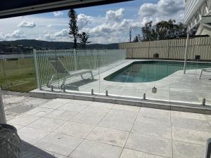 a swimming pool with a chair next to a building at Bayview Luxury Waterfront Escape with Pool & Spa in Green Point