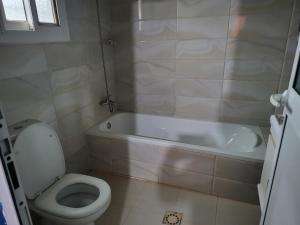 a bathroom with a white tub and a toilet at Tish home away from home in Safim