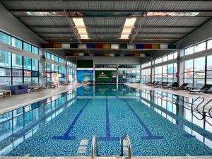a large swimming pool with chairs in a building at Sapaly Lao Cai City Hotel in Lao Cai