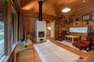 a living room with a fireplace in a log cabin at Four Seasons B22 by Hi Ylläs in Ylläsjärvi