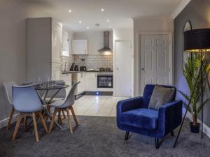 a kitchen with a blue chair and a dining room at Charming Ground-Floor Flat in Huddersfield +5 photos
