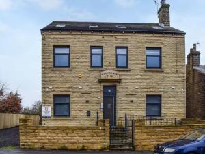 a brick building with a car parked in front of it at Charming Ground-Floor Flat in Huddersfield