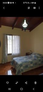 ein Schlafzimmer mit einem Bett, einem Fenster und einer Lampe in der Unterkunft Casa en las Sierras de Cordoba in Villa Parque Siquiman