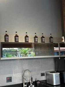 a shelf with bottles of whiskey on it in a kitchen at Rancho Recanto dos Pássaros in Limeira +9 photos