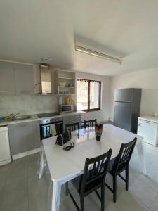 una cocina con una gran mesa blanca y sillas en Magnifique grand appartement dans le Morvan, en Château-Chinon