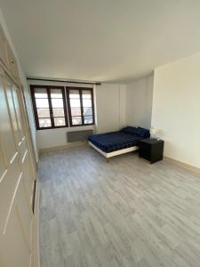 Habitación vacía con cama y escritorio. en Magnifique grand appartement dans le Morvan, en Château-Chinon 1 foto más
