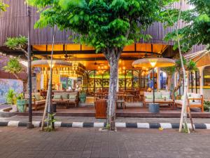 a restaurant with tables and chairs and umbrellas at Natya Hotel Tanah Lot in Tanah Lot