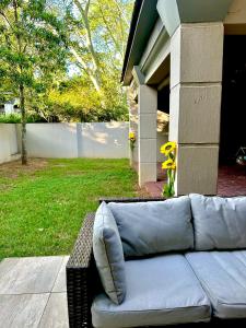un sofá sentado en el porche de una casa en Riverside Gardens 2 bedroom Home, en Nelspruit