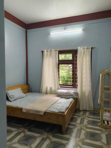 a bedroom with a bed and a window at Sirful Homestay in Pedong