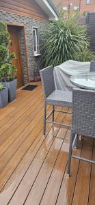 zwei Stühle und ein Tisch auf einem Holzdeck in der Unterkunft Cosy Studio Quest House in Romford