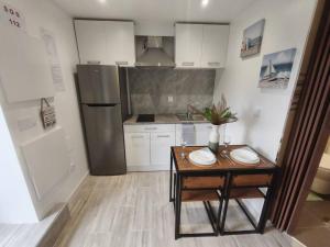 a small kitchen with a table and a refrigerator at Alojamiento Local - Estrela in Seixal +7 photos