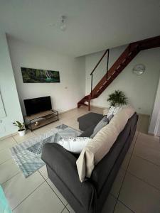 a living room with a couch and a tv at Au coin de la cheminée in Saint-Leu